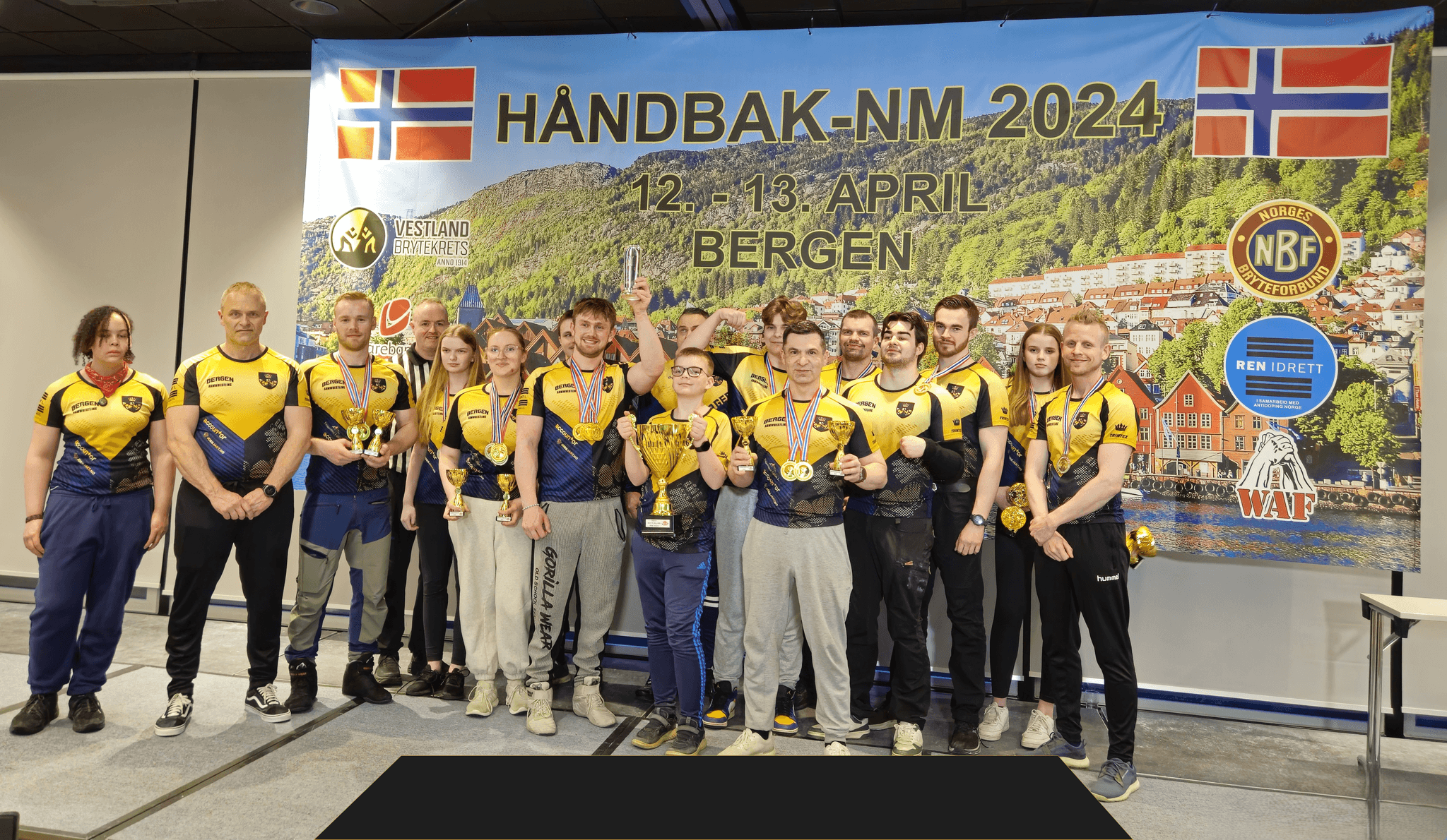 Glade medlemmer hos Bergen Armwrestling som poserer foran kamera